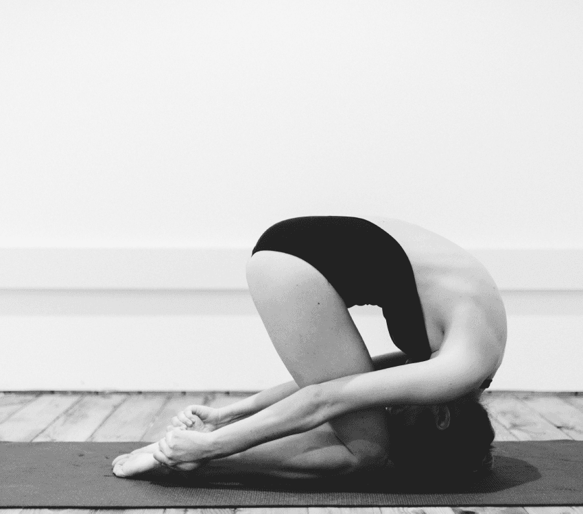A student folded forward in a seated pose